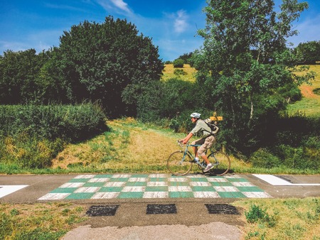 July 21, 2017. Transport and roads in the france region of the Burgundy. Bicycle route, service road in rural areas in summer. Road signs and warnings in Europe. Cyclist man riding a bicycle road.のeditorial素材