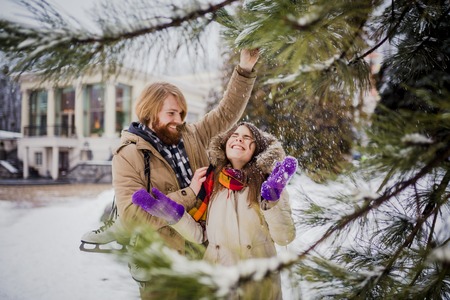 Young loving couple Caucasian man with blond long hair and beard, woman with toothy smile have fun,...