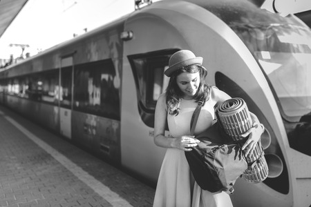 theme railway and travel. Portrait young caucasian woman with toothy smile standing at train station...