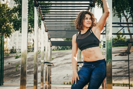 The theme women sports and health. Beautiful sexy caucasian woman with curly long hair posing on...