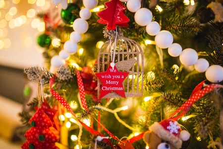 New Year decoration in the form of a red star on a Christmas tree with the inscription we wish you a merry christmas.の写真素材