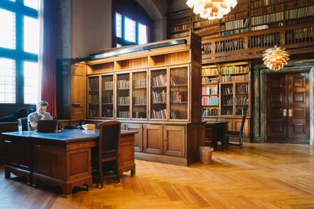 Storage of books. Large old library in the Gothic style. Shelves and rows with books. City Library at the City Hall of Denmark Copenhagen 18 February 2019.のeditorial素材