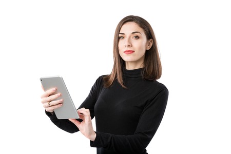 Woman business technology theme. Beautiful young caucasian woman in black shirt posing standing with tablet hands on white isolate background. Profession Marketer Sales Social Media Advertising.の写真素材