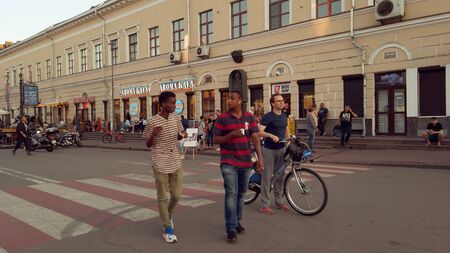 Ukraine, Kiev, July 7, 2019. downtown pedestrian street. Old historical street in Kiev. lot people, a crowd of tourists walks on a holiday weekend at sunset in the summer. Cyclist on a rental bike.のeditorial素材