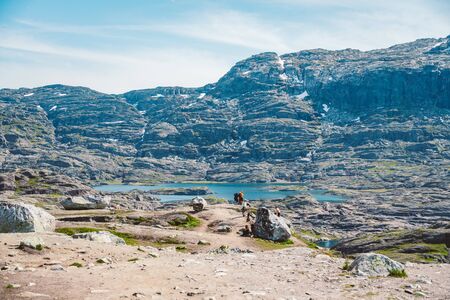 July 26, 2019. Norway tourist route on the trolltunga. People tourists go hiking in the mountains of Norway in fine sunny weather to thetrolltunga. Hiking backpack theme.のeditorial素材