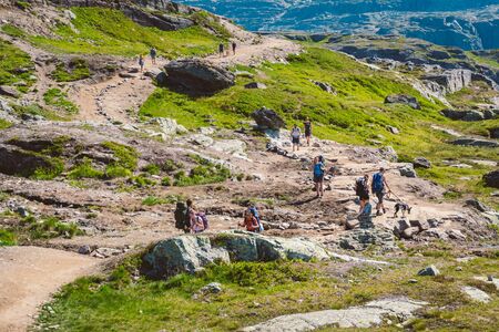 July 26, 2019. Norway tourist route on the trolltunga. People tourists go hiking in the mountains of Norway in fine sunny weather to thetrolltunga. Hiking backpack theme.のeditorial素材