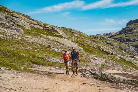 July 26, 2019. Norway tourist route on the trolltunga. People tourists go hiking in the mountains of Norway in fine sunny weather to thetrolltunga. Hiking backpack theme.のeditorial素材