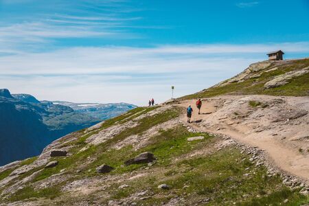 July 26, 2019. Norway tourist route on the trolltunga. People tourists go hiking in the mountains of Norway in fine sunny weather to thetrolltunga. Hiking backpack theme.のeditorial素材