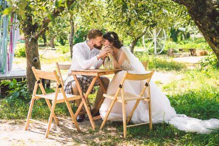 Attractive couple newlyweds, happy and joyful moment. bride and groom sit at table set for two in...