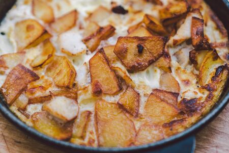 Potatoes baked with meat in the oven. Delicious dinner recipe. Potato pudding. Baked potato. Beef casserole. Potato gratin.Baked potatoes with eggs and chicken in a round bowl on a wooden table.の写真素材
