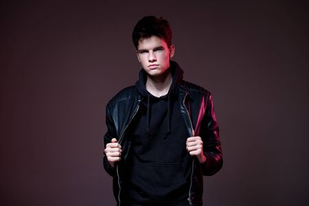 Attractive young guy posing in studio. Young caucasian guy model in black clothes posing in the...