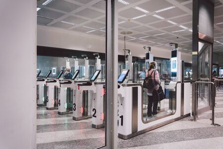 Air travelers pass through automated passport border control gates Milano Malpensa Airport....
