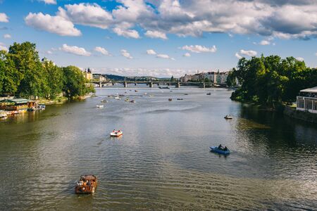 Panorama of Prague, a lot of catamaran floats on the river. Catamarans with resting tourists floating on the river at the Charles Bridge, in the historic. Prague Czech Republic.の写真素材