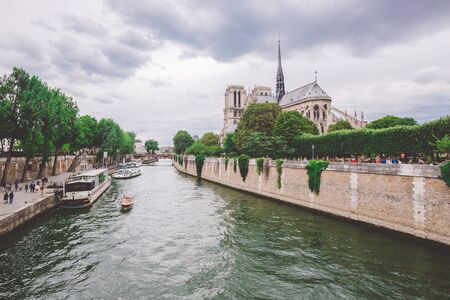 July 23, 2017. Paris, France. Notre dame cathedral from river Seine in Paris. Notre dame cathedral from river Seine Paris, France. Beautiful view of a canal-boat and the Notre-Dame Cathedral.のeditorial素材