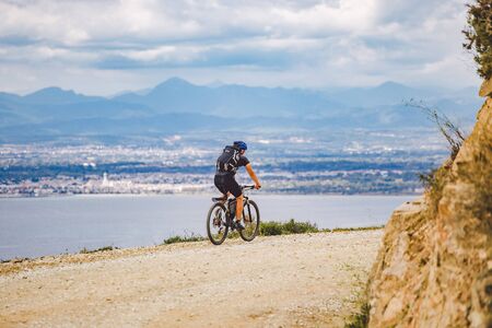 young guy riding a mountain bike on a bicycle route in Spain. Athlete on a mountain bike rides...