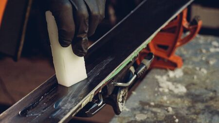 Applying Ski Wax To Ski Base with iron. Ski base tuning and paraffin bars. skiing service repair....