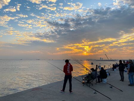 Fishermen fishing at sunset on the shores of the Sea of Marmara in Istanbul Turkey on October 28, 2019.のeditorial素材