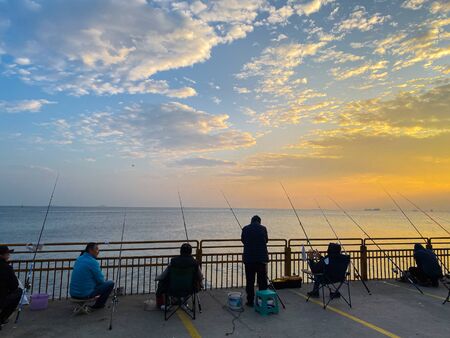 Fishermen fishing at sunset on the shores of the Sea of Marmara in Istanbul Turkey on October 28,...