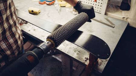 Base polishing, final ski polishing. In hands electric brush rotor. rotary brush use ski repair...