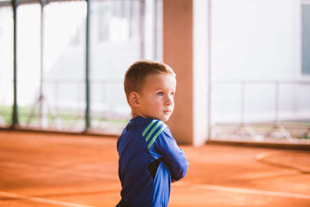 Child playing tennis on outdoor court. September 20, 2016. Ukraine, Kiev. Little tennis great player. Children sportswear adidas. Child athlete Ambassador Adidas.のeditorial素材