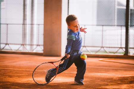 Child playing tennis on outdoor court. September 20, 2016. Ukraine, Kiev. Little tennis great player. Children sportswear adidas. Child athlete Ambassador Adidas.のeditorial素材