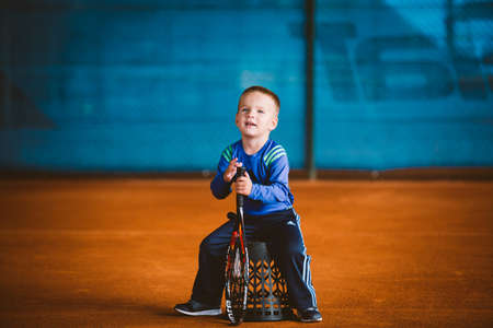 Child playing tennis on outdoor court. September 20, 2016. Ukraine, Kiev. Little tennis great player. Children sportswear adidas. Child athlete Ambassador Adidas.のeditorial素材