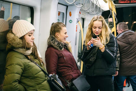 Interior view of a Copenhagen driverless metro train with passengers. Theme city passenger transport in Copenhagen. Subway in Denmark Copenhagen, February 18, 2019. People in the modern European metroのeditorial素材