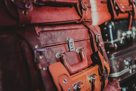A lot of Old vintage suitcases. Abstract background as travel, journey, voyage concept. A lot of vintage suitcases stacked vertically. Pile of many travel bags.の写真素材