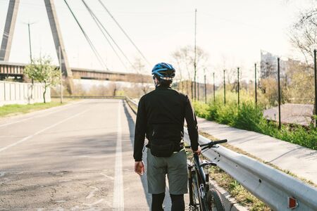 male cyclist on mountain bike in protective mask respirator in polluted city. guy ride to work on environmentally friendly transport, urban eco raffic. Face pollution mask smog dust pm2.5 protection.の写真素材