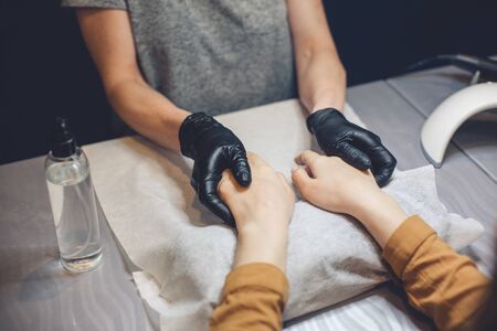 Beautician applying cream on client hands. Beauty salon. Hands Massage. Manicure at salon. Spa Manicure concept. Female hands with delicate manicure and moisturizing cream. Soft skin. Hand, beauty.の写真素材