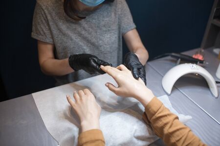 Beauty salon, applying moisturizing cream on client hands and massaging. Manicure at the salon. SPA manicure, hand massage and body care. Close up. Soft skin. Cosmetology, applying.の写真素材