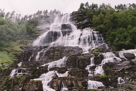 view of Tvindefossen or Tvinnefossen waterfall near Voss, Norway. Natural, landscape. Tvinde Camping. Marquee, rocksの写真素材