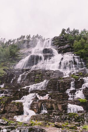 view of Tvindefossen or Tvinnefossen waterfall near Voss, Norway. Natural, landscape. Tvinde Camping. Marquee, rocksの写真素材