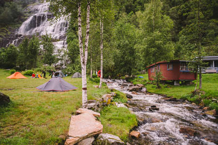 Tvinde Camping tents on the background of a waterfall Tvindefossen in Norway near Voss. Campsite in the norwegian fjords.のeditorial素材