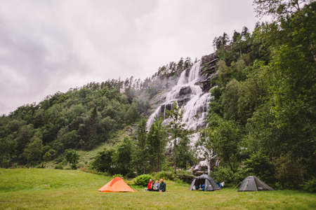 Tvinde Camping tents on the background of a waterfall Tvindefossen in Norway near Voss. Campsite in the norwegian fjords.のeditorial素材