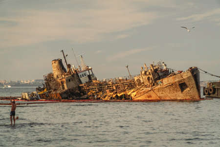 The wreck of tanker Delfi on Odessa beach. Ecological disaster, oil spill on city beaches as. Submerged oil tanker Delfi near Black Sea coast in Ukraine 26 August 2020. Tanker wreck on a public beach.のeditorial素材