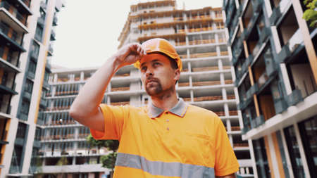 Construction worker putting on his safety gear helmet at job site. Safety first, profession concept....