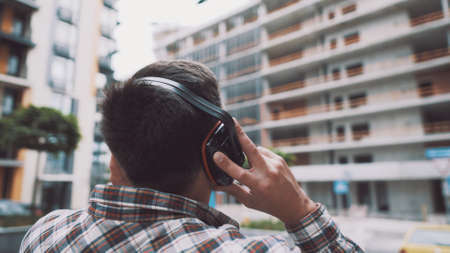 Builder covers his ears, ear muff to protect workers ears. Construction worker wearing protective...