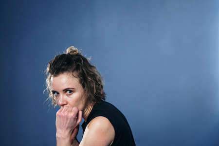 Caucasian young woman practicing mixed martial arts, throw punches looking into art camera in gym. Taekwondo training concept. Her technique is flawless. Fight. Karate girl. Fighting stance.の写真素材