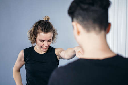 Female taekwondo instructor conducts personal training session for young woman at gym. Girl...