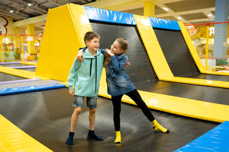 Children are active leisure. Sports weekend in sports center of acrobatics and trampoline. Physical education. Children having fun on trampoline in entertainment center, childhood and sporty lifestyleの写真素材
