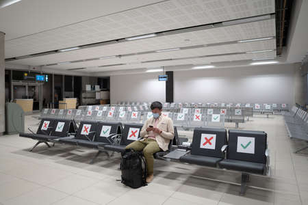 Traveler sits at international airport of Cyprus, Paphos during  crisis, sits in terminal on seat...
