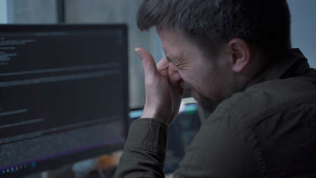 Tired male working on computer. Sad exhausted man at home office. Stressful work, stress at...