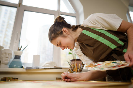 Art, creativity, hobby and creative occupation concept. Bringing creativity to life. Woman painting in art studio. Attractive female artist painting in workshop. Woman hobby, activity, profession.の写真素材