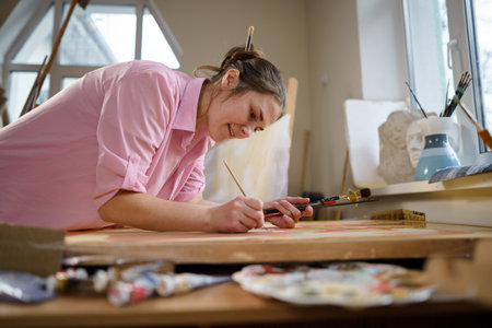Art, creativity, hobby and creative occupation concept. Bringing creativity to life. Woman painting in art studio. Attractive female artist painting in workshop. Woman hobby, activity, profession.の写真素材