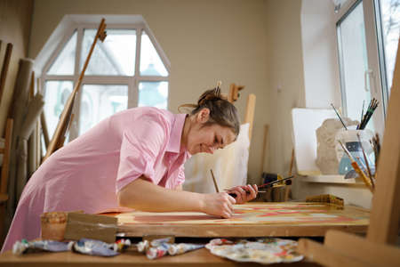 Art, creativity, hobby and creative occupation concept. Bringing creativity to life. Woman painting...
