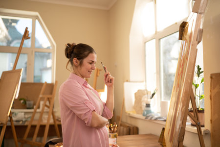 Art, creativity, hobby and creative occupation concept. Bringing creativity to life. Woman painting in art studio. Attractive female artist painting in workshop. Woman hobby, activity, profession.の写真素材