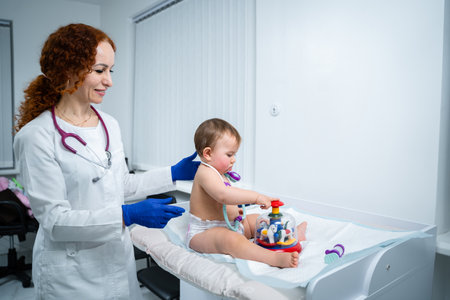 Pediatrician providing healthcare for her baby patient in the office of a specialized clinic for children. Neonatologist. Medical appointment little child one year old in the clinic. Health care of infant, children, kid.の写真素材