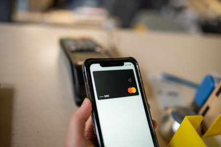 Woman hand paying using NFC technology. Customer paying through mobile phone using contactless...