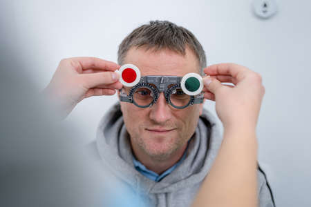 Male patient undergoes an eye test and prescription for eyeglasses in ophthalmology clinic....